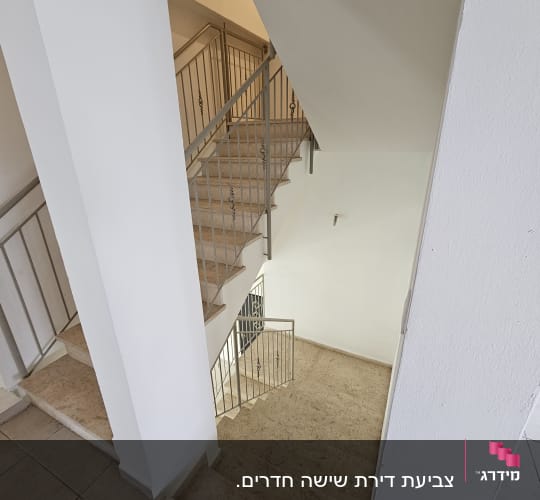 גרם מדרגות עם מעקה מתכת וקירות לבנים